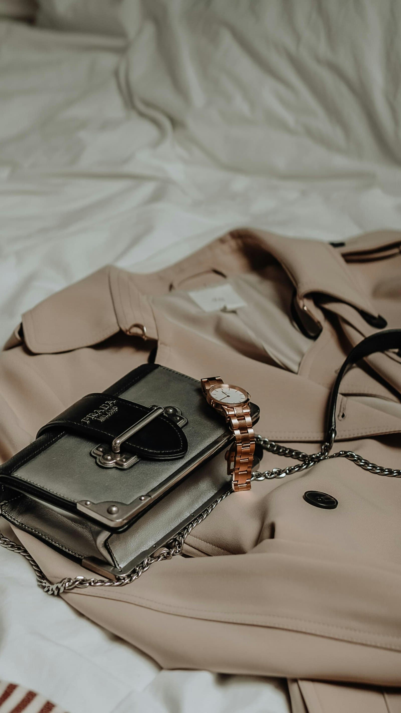 A handbag and watch on a coat