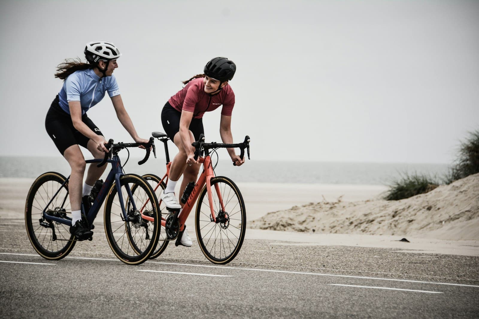 Two road cyclists by the sea