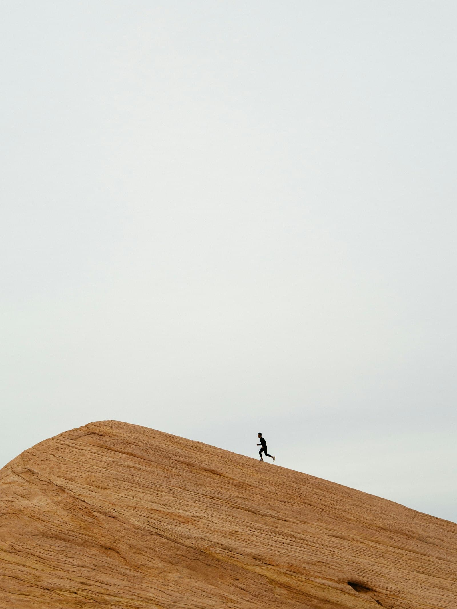 A runner on top of a sandy hill