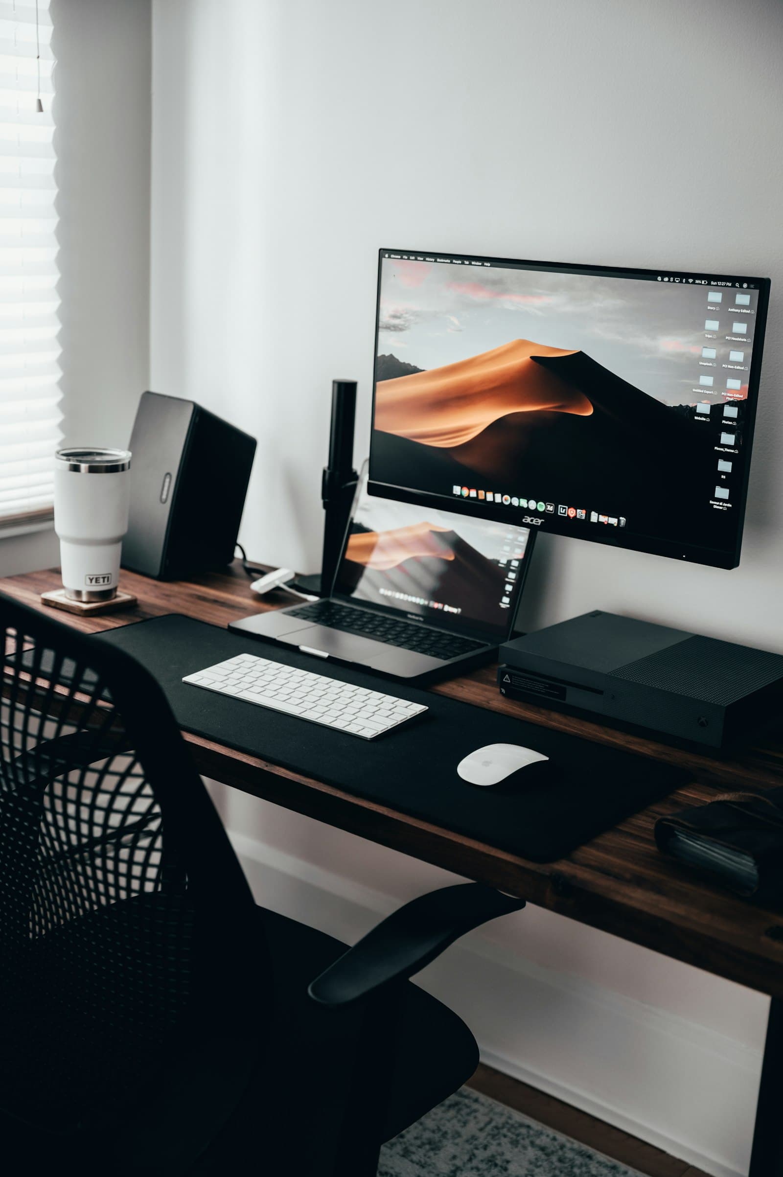 A desk with a monitor and laptop
