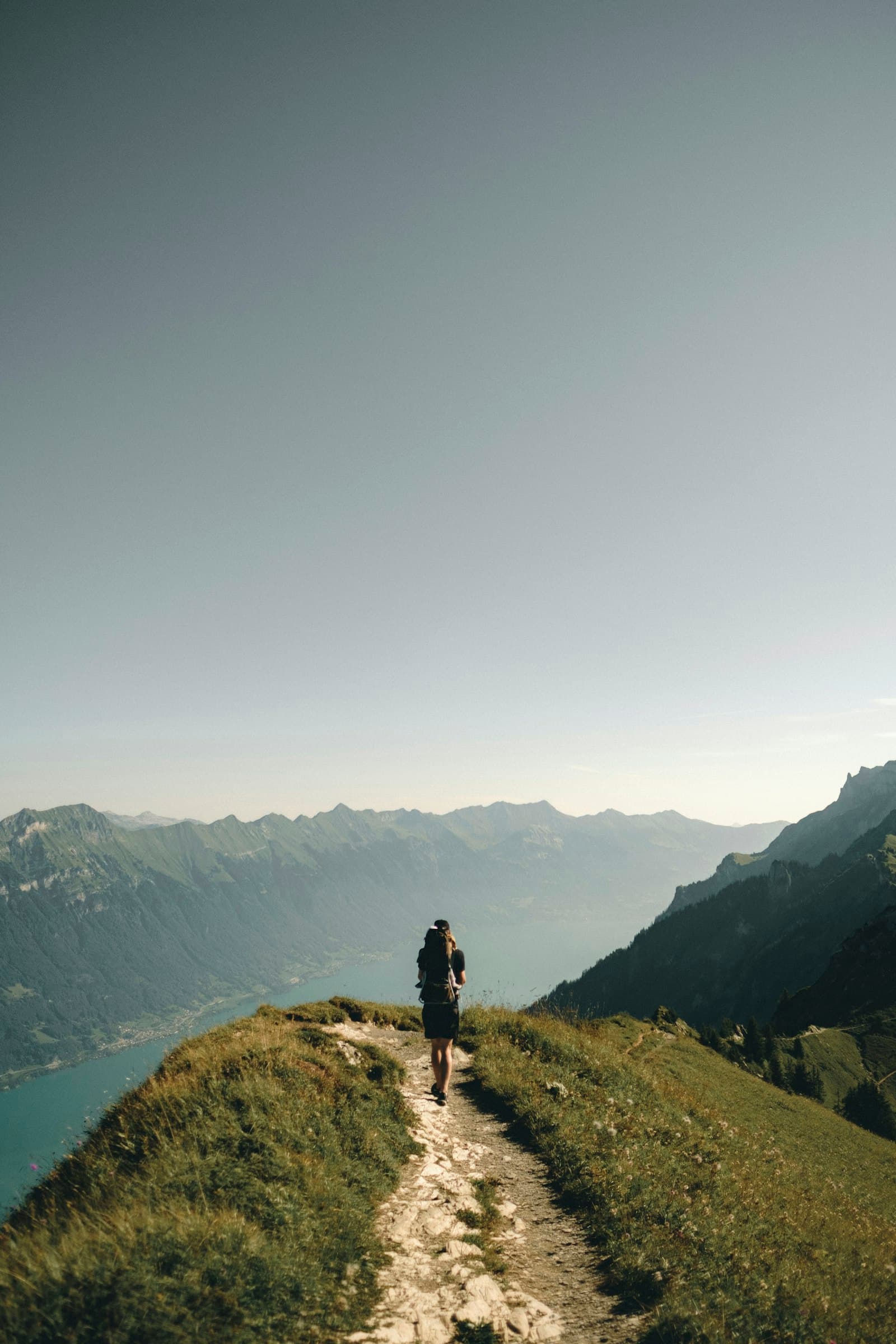 A hiker on a mountain path above a river